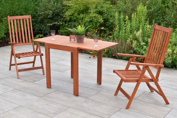 Gartenszene mit Holztisch und Stühlen auf einer Terrasse