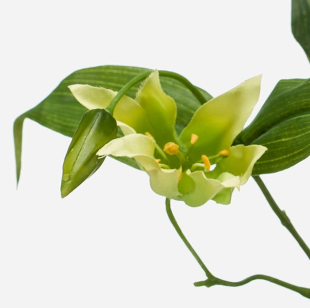 Kunstblume mit einer offenen Blüte, einer Knospe und grünen Blättern.