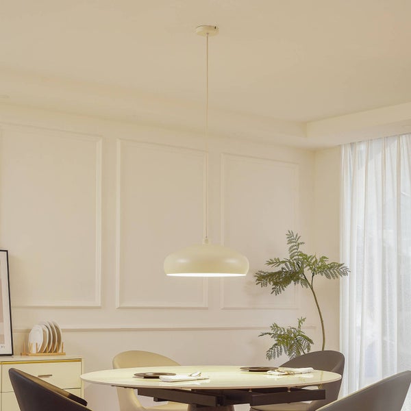 Moderne Pendelleuchte mit flachem Schirm über einem Esstisch in einem hellen, aufgeräumten Esszimmer mit Wandleisten und einer Pflanze.