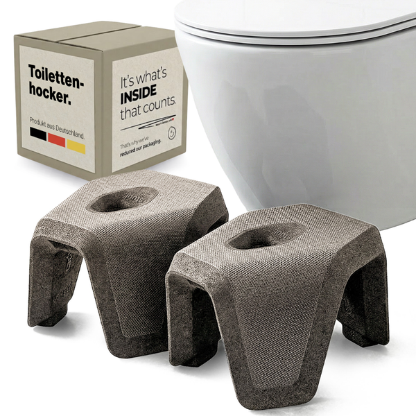 Zweiteiliger ergonomischer Toilettenhocker mit texturierter Oberfläche neben einer Toilette und dem Verpackungskarton.