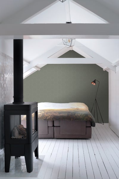 Schlafzimmer mit Kaminofen, Boxspringbett und Stehlampe