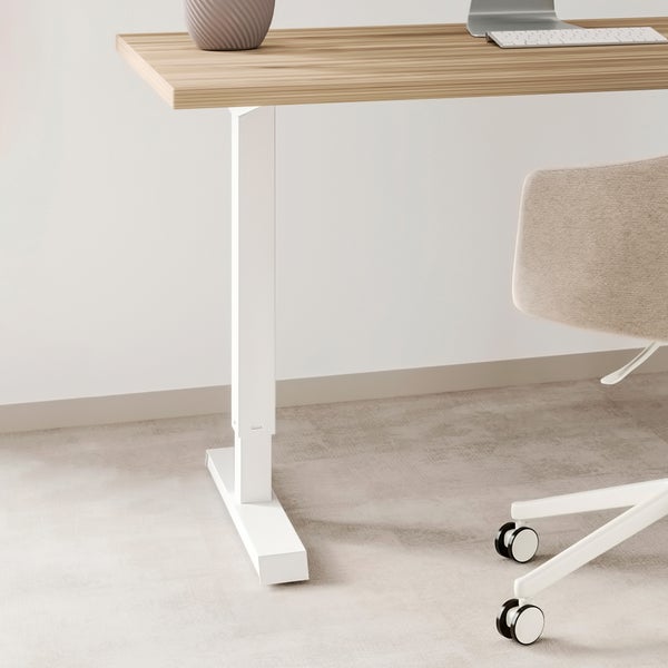 Ein höhenverstellbarer Schreibtisch mit einer hellen Holzplatte und einem stabilen Gestell in einem Büro.