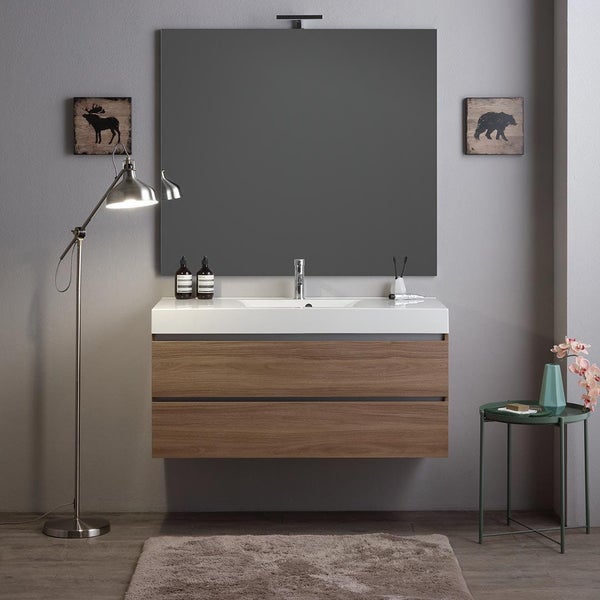 Modernes Badezimmer mit Waschtischunterschrank in Holzoptik, weißem Waschbecken, großem Spiegel und Stehlampe im ansprechenden Design.
