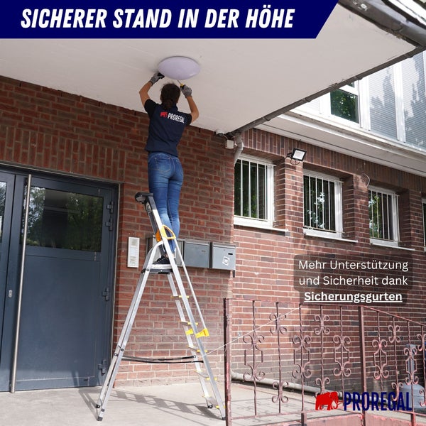 Frau auf Mehrzweckleiter bei Montage einer Deckenleuchte vor Backsteingebäude