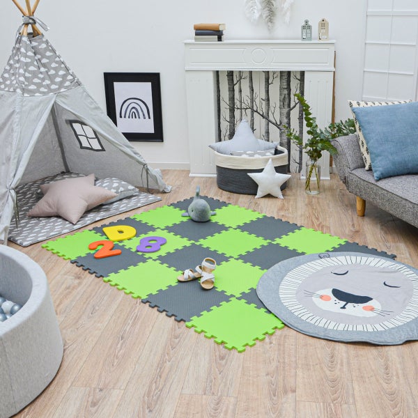 Hell gestaltetes Kinderzimmer mit gemustertem Tipi-Zelt, einer Puzzlematte aus Schaumstoff und einem runden Löwen-Teppich auf Holzboden.