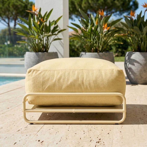 Outdoor-Hocker mit Metallgestell und weichem Polster auf einer Terrasse am Pool, umgeben von großen Pflanzenkübeln.