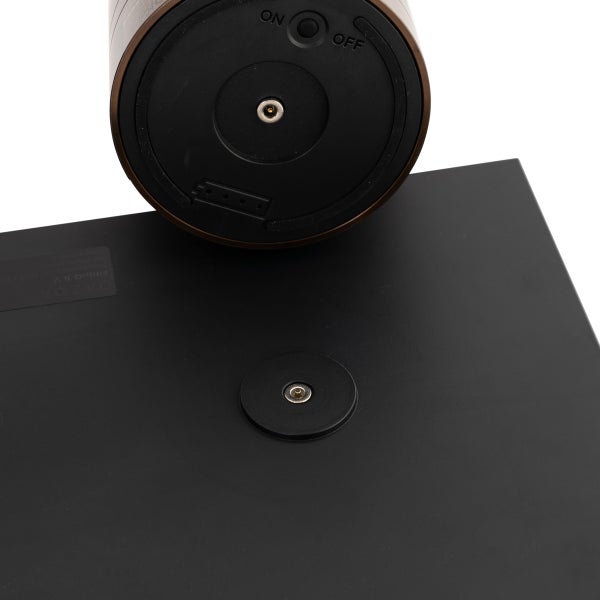 Unterseite einer Tischleuchte aus Metall mit Ein- und Ausschalter und magnetischem Ladekontakt sowie eine flache Ladestation.