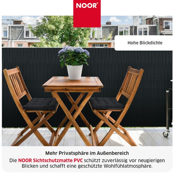 NOOR Sichtschutzmatte aus PVC mit hoher Blickdichte auf einem Balkon mit Holzmöbeln und Pflanze.