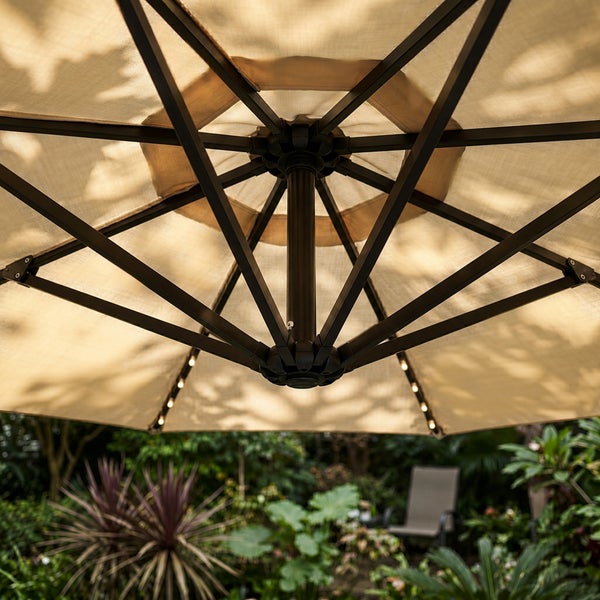 Unteransicht eines Sonnenschirms mit Metallgestell und integrierter Beleuchtung an den Streben in einem Garten.