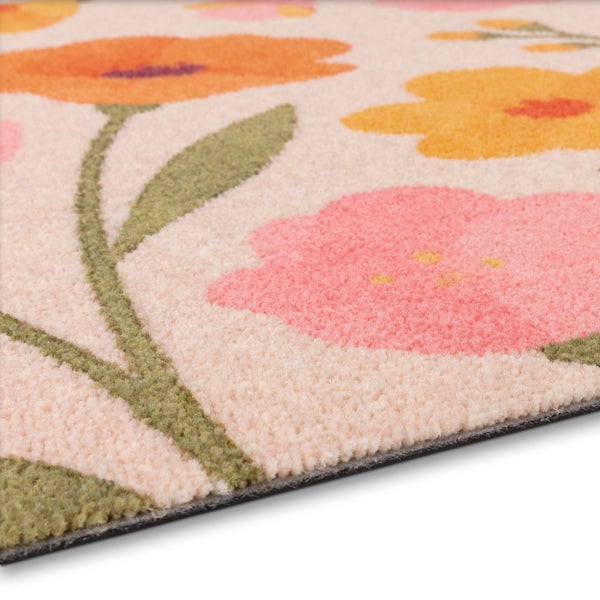 Detailaufnahme eines Teppichs mit Blumenmuster und weichem Flor.