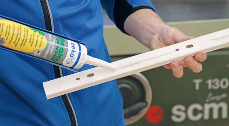 Auftragen von beko Hybrid POP flexiblem Kleb- und Dichtstoff aus einer Kartusche auf eine weiße Profilleiste.