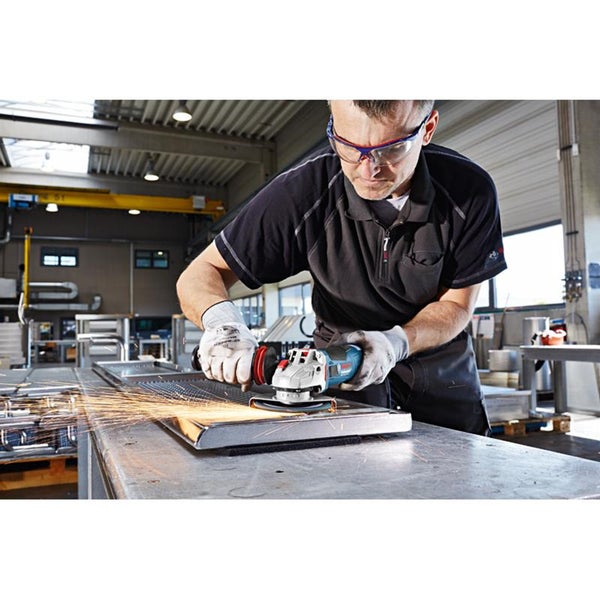Handwerker bearbeitet eine Metallplatte mit einem Winkelschleifer von Bosch Professional in einer Werkstatt.