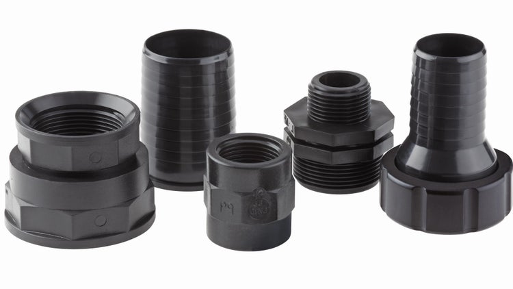 Verschiedene schwarze Rohrverschraubungen und Schlauchanschlüsse aus Kunststoff für die Gartenbewässerung.