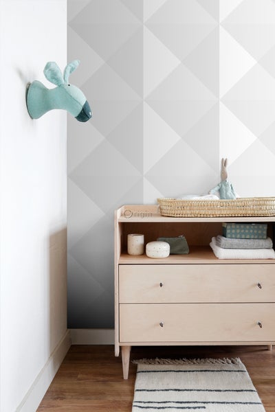 Babyzimmer mit Wickelkommode, Wanddekoration und geometrischer Tapete