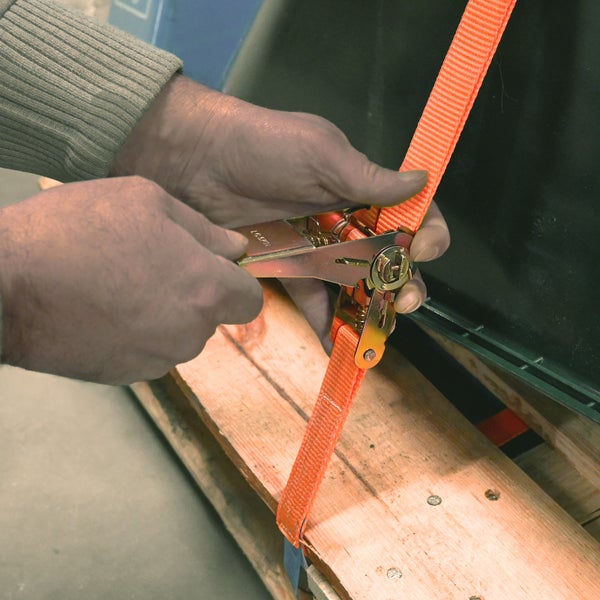 Zurren eines Palettenbehälters mit einem Ratschengurt.