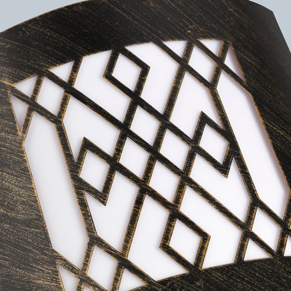 Nahaufnahme eines dekorativen Metallpaneels mit geometrischem Gittermuster und antikem Bronze-Finish.