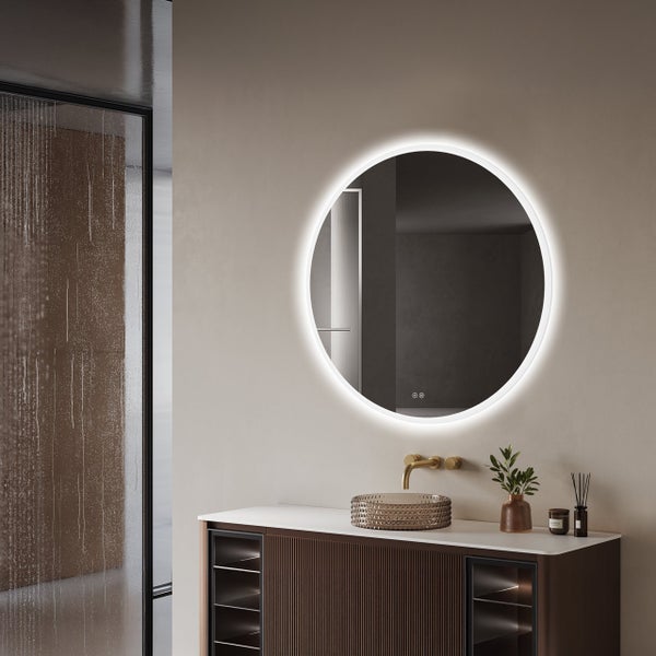 Runder LED Badezimmerspiegel mit indirekter Beleuchtung über einem modernen Waschtisch mit Waschbecken und Armatur in einem Badezimmer.