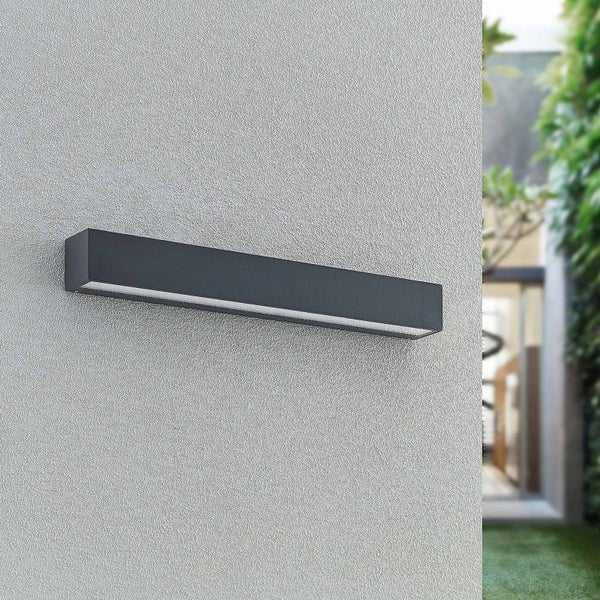 Moderne schwarze LED-Außenwandleuchte in rechteckiger Form an einer verputzten Fassade.
