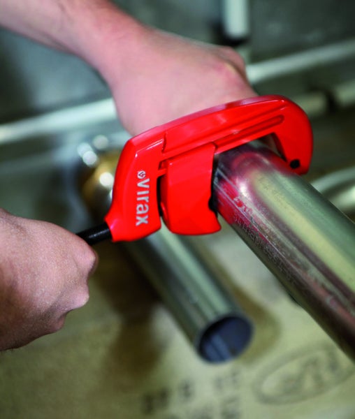 Virax Rohrabschneider beim Schneiden eines Metallrohrs. Virax Logo.