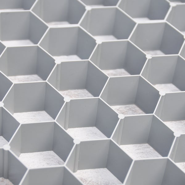 Graue Kiesstabilisierungsmatte aus Kunststoff mit sechseckiger Wabenstruktur zur Bodenbefestigung.