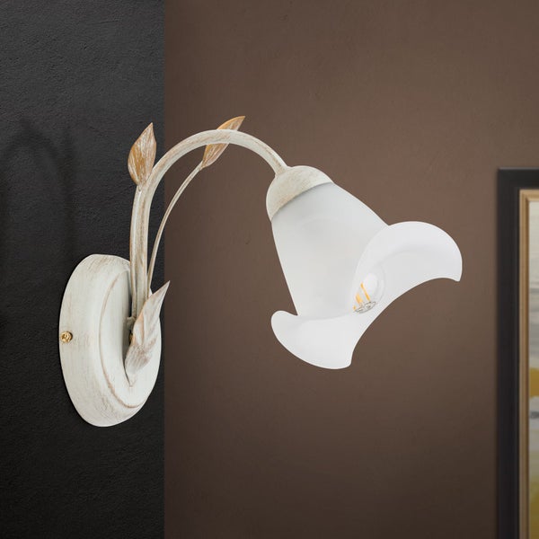 Wandleuchte im Blumen Design mit mattem Glasschirm und antik wirkendem Metallgestell in geschwungener Blattform.