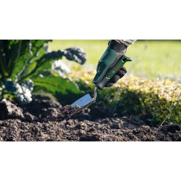 Gartenarbeitsszene mit Handschuhen und einer Pflanzschaufel von Bosch beim Umgraben der Erde.