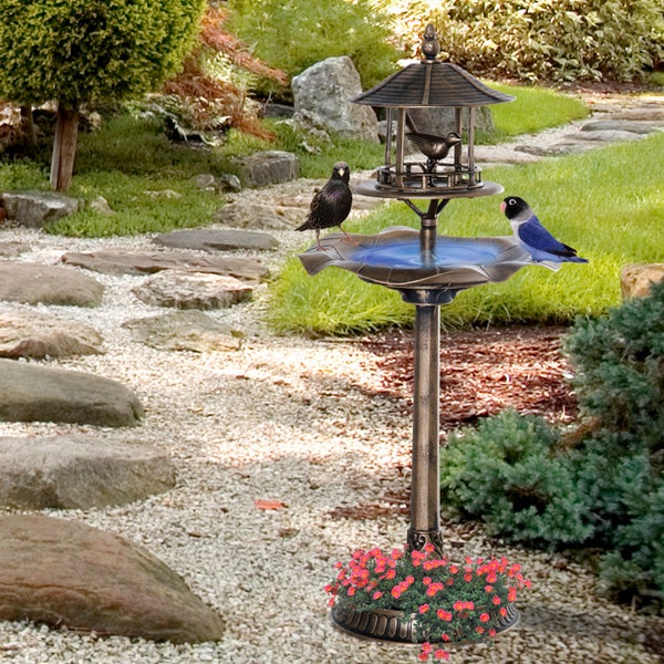 Dekorative Vogeltränke und Futterstation für den Garten mit integrierter Pflanzschale am Fuß, platziert auf einem hellen Gartenweg.