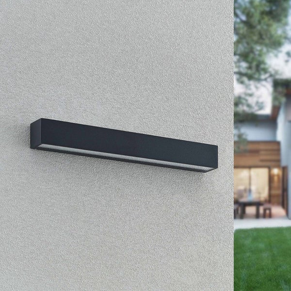 Moderne, längliche LED-Außenwandleuchte in Schwarz montiert an einer Fassade.