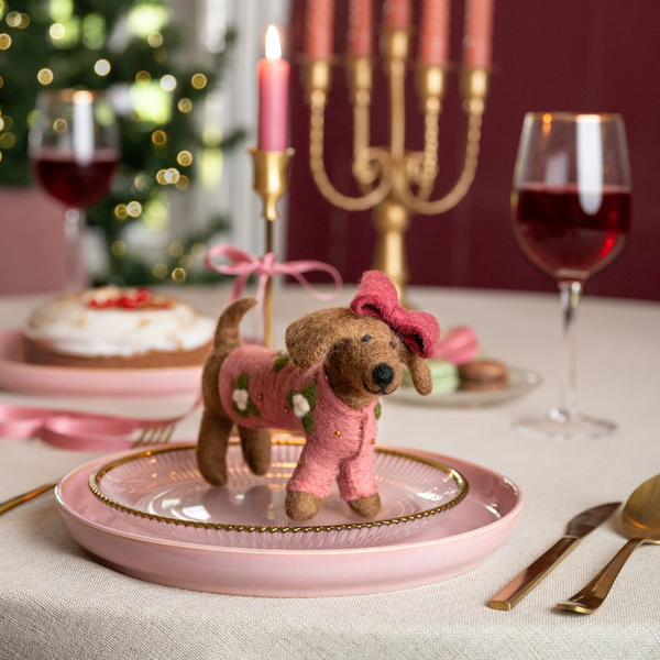 Festliche Tischdekoration mit Hundefigur, Kerzen und Getränken
