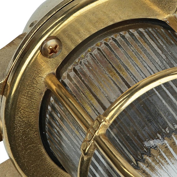 Detailaufnahme einer goldenen Schiffslampe mit geriffeltem Glas