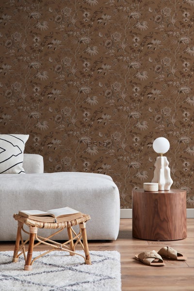 Wohnzimmer mit brauner Blumentapete, Sofa, Beistelltisch und dekorativen Elementen für eine gemütliche Atmosphäre