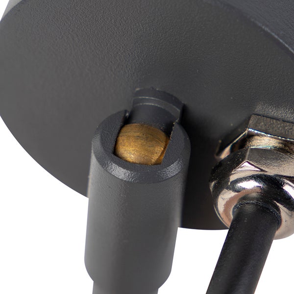 Nahaufnahme eines Gelenks und Kabelauslasses einer Leuchte aus anthrazitfarbenem Metall mit einem Kugelgelenk aus Messing.