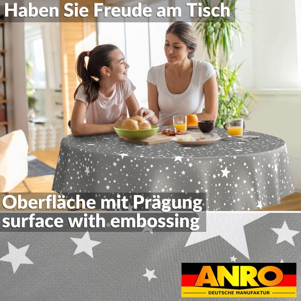 Runde Tischdecke mit Sternmuster und geprägter Oberfläche, auf einem Esstisch in einem hellen Raum mit Frau und Kind. ANRO Logo.
