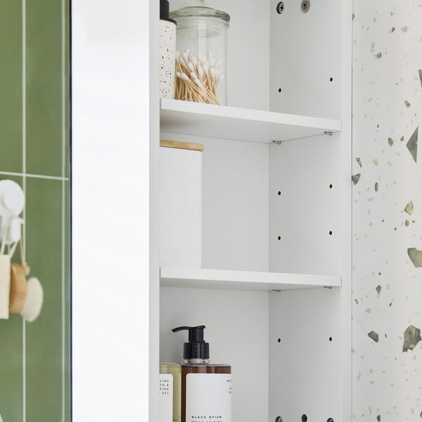 Detailansicht eines weißen Badezimmerschranks mit Einlegeböden und diversen Badartikeln