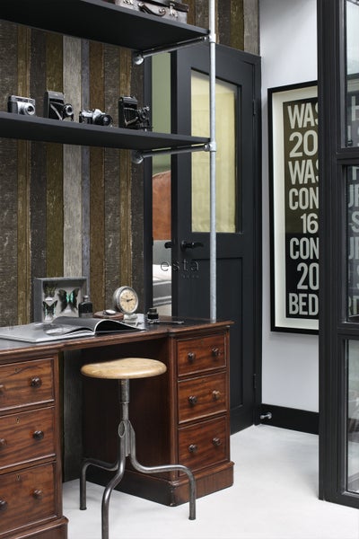 Inneneinrichtung mit Schreibtisch, Stuhl, Regalen und dekorativen Elementen für einen Arbeitsbereich.