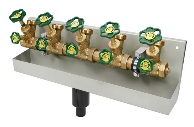 Wasserverteiler aus Messing mit grünen Handrädern auf einer Wandhalterung mit Auffangschale und Ablauf.