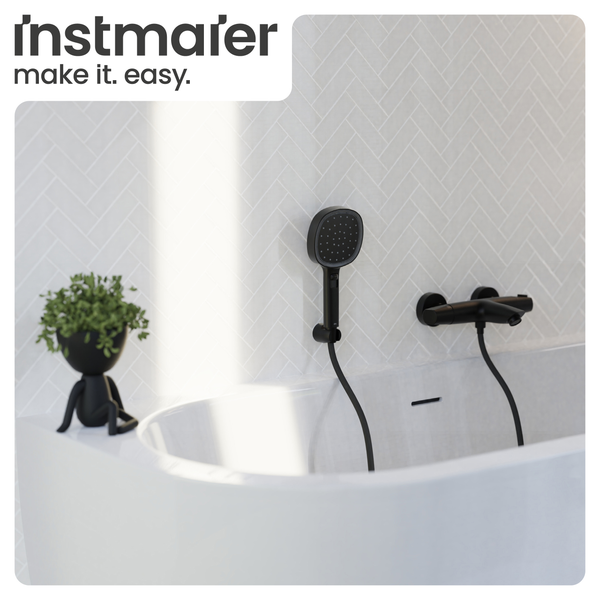 Instmaier Logo. Schwarze Badewannenarmatur mit Handbrause an einer Wand mit Fischgrätenmuster über einer weißen Badewanne.