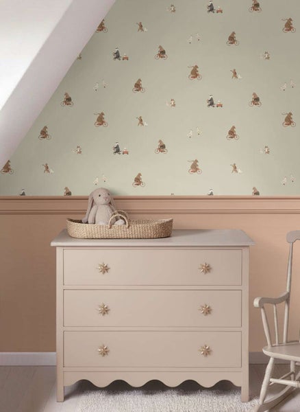 Kindertapete mit Tiermotiven an einer Wand in einem Babyzimmer mit Kommode