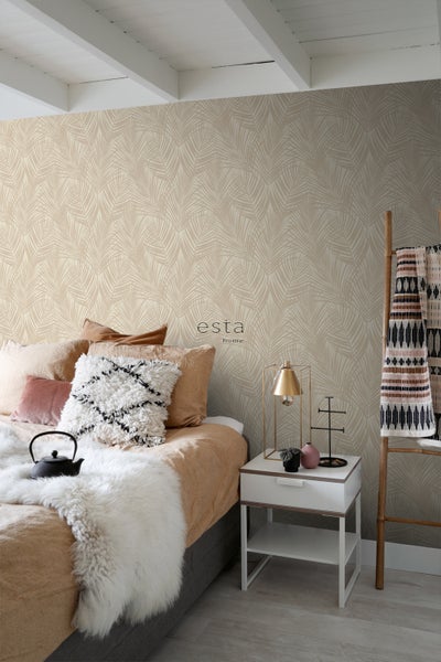 Schlafzimmer mit Bett, Nachttisch, Leiter und Tapete mit Blattmuster.