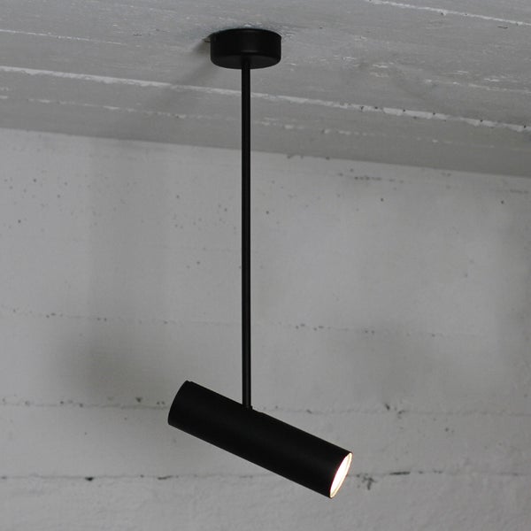 Schwarze Deckenleuchte mit zylindrischem Lampenschirm.