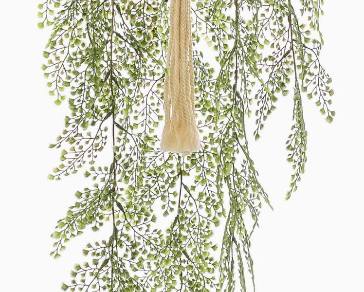 Künstliche Hängepflanze mit feinen grünen Blättern und einer hellen Kordelaufhängung.