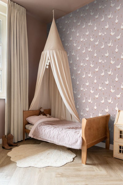 Gemütliches Kinderzimmer mit Himmelbett, Tapete mit Gänsemotiv und hellem Teppich