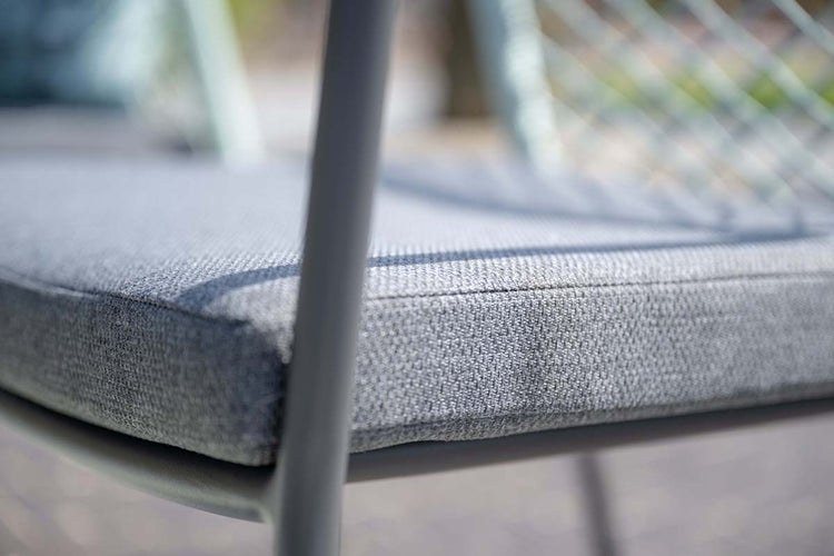 Nahaufnahme eines Sitzkissens aus gewebtem Stoff auf einem Metallrahmen.