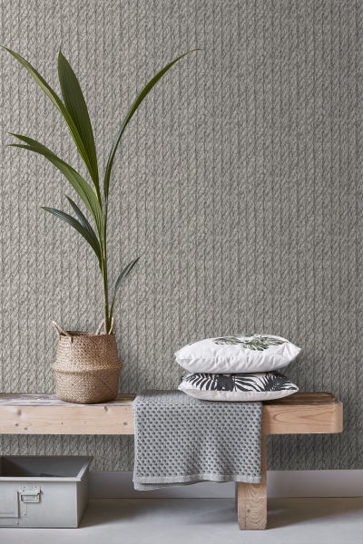 Dekoratives Zimmer mit Textiltapete, Bank und Pflanzenarrangement