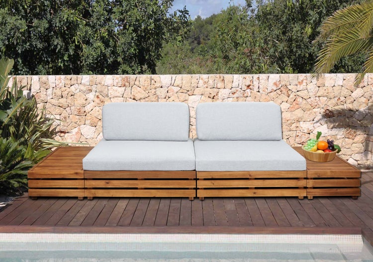 Helle, moderne Gartenlounge aus Holzlatten mit hellgrauen Polstern auf einer organisierten Holzterrasse vor einer Natursteinmauer am Pool.