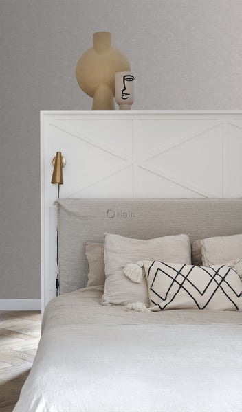 Schlafzimmer mit Bett, Kissen und dekorativen Vasen