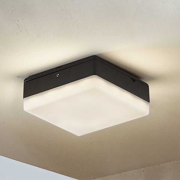 Quadratische Deckenleuchte mit dunklem Rahmen und weißem Diffusor, montiert an der Decke und eingeschaltet.
