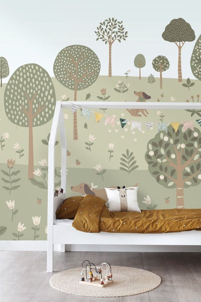 Kinderzimmer mit weißem Hausbett aus Holz und Vliestapete mit Naturmotiv aus Bäumen, Blumen und Hunden in Grüntönen.