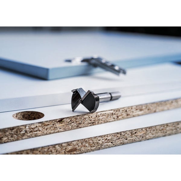 Forstnerbohrer auf beschichteter Spanplatte mit Bohrloch