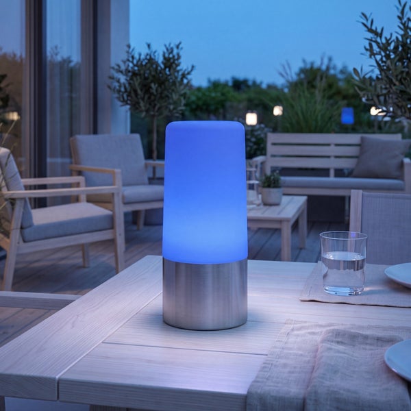 Moderne LED Tischleuchte für den Außenbereich mit zylindrischem Leuchtkörper aus Kunststoff auf einem Metallsockel auf einem Terrassentisch.